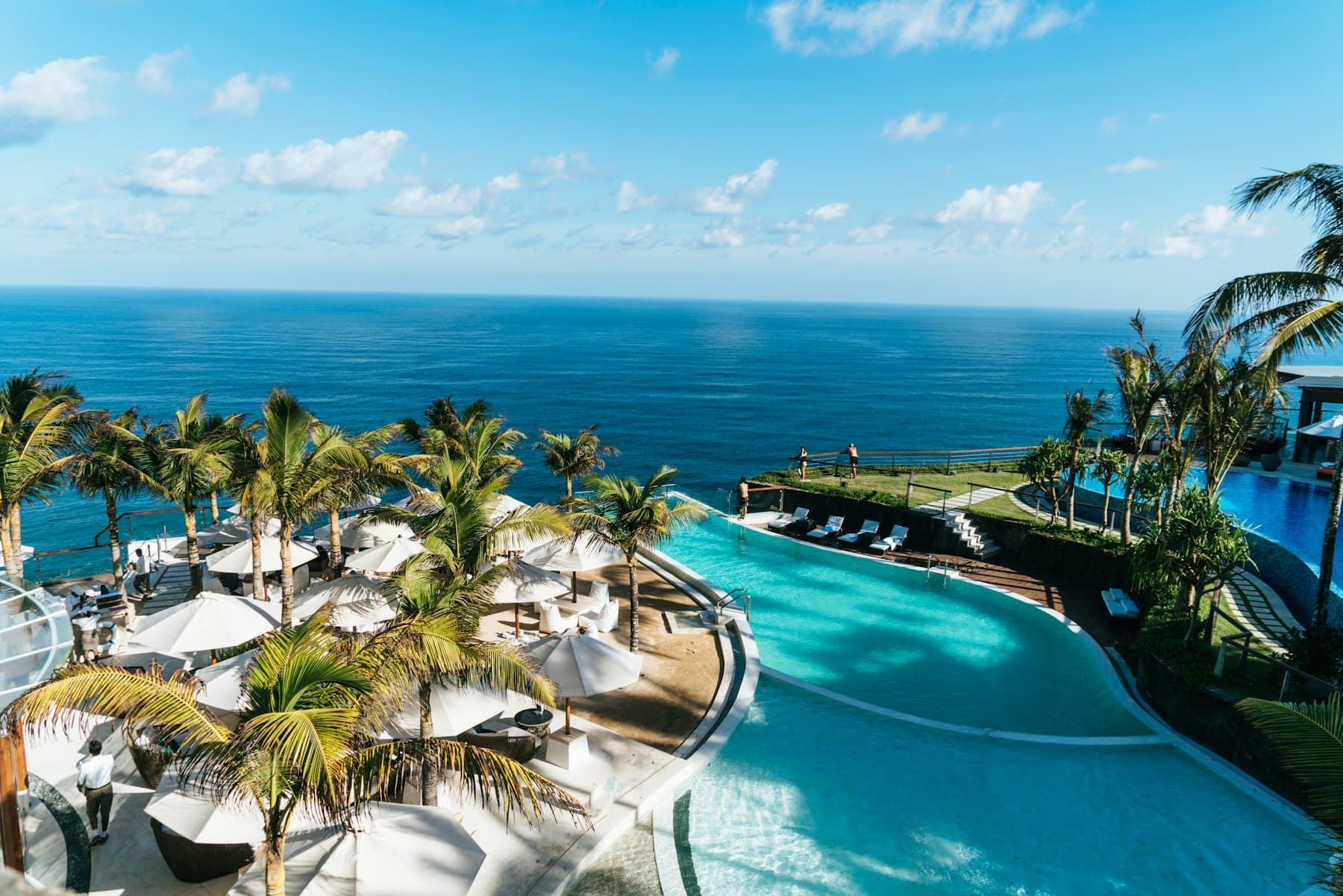 Piscina de resort à beira-mar cercada de coqueiros