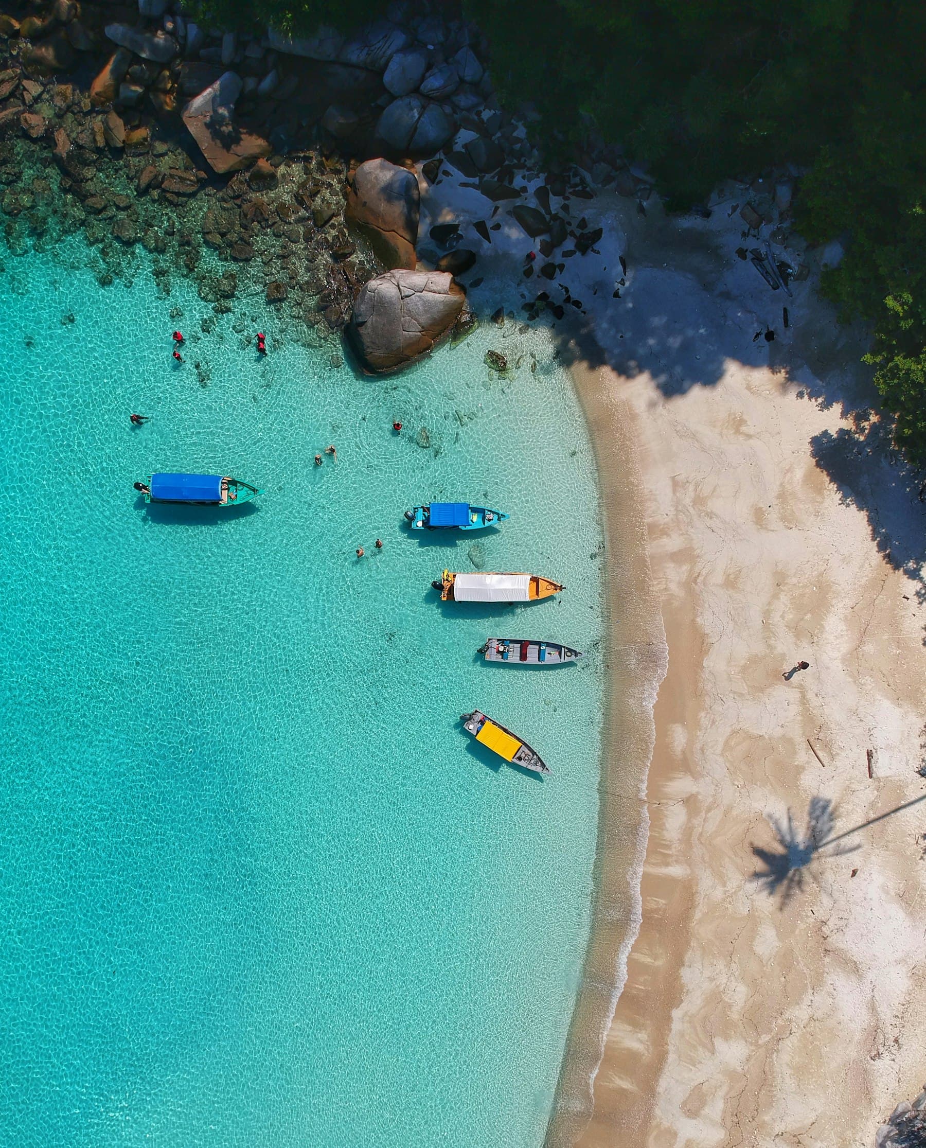 Mar azul-turquesa com barcos ancorados perto da areia
